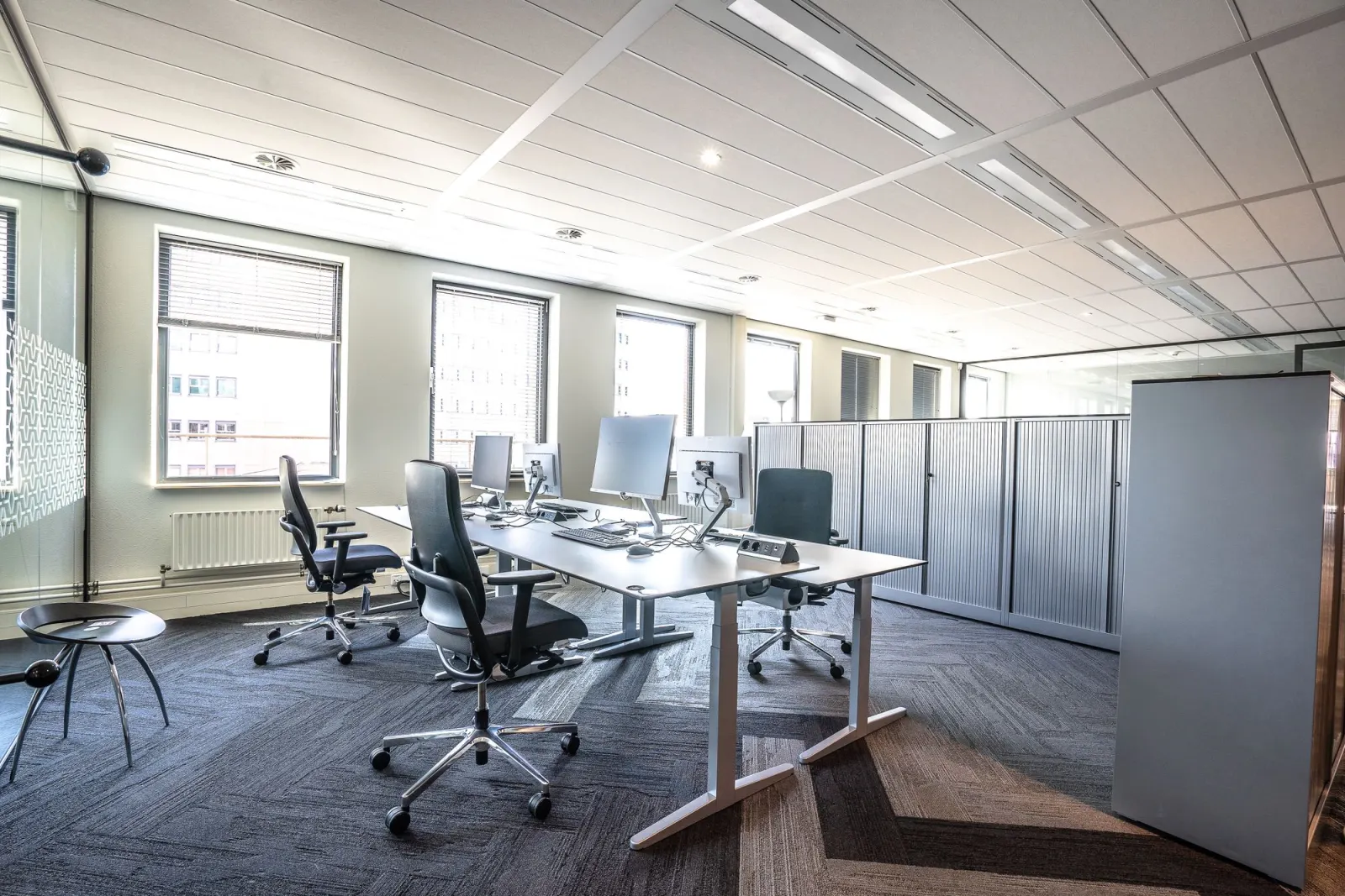 Çalışma masaları ve ergonomik sandalyelerle kurulmuş açık ofis