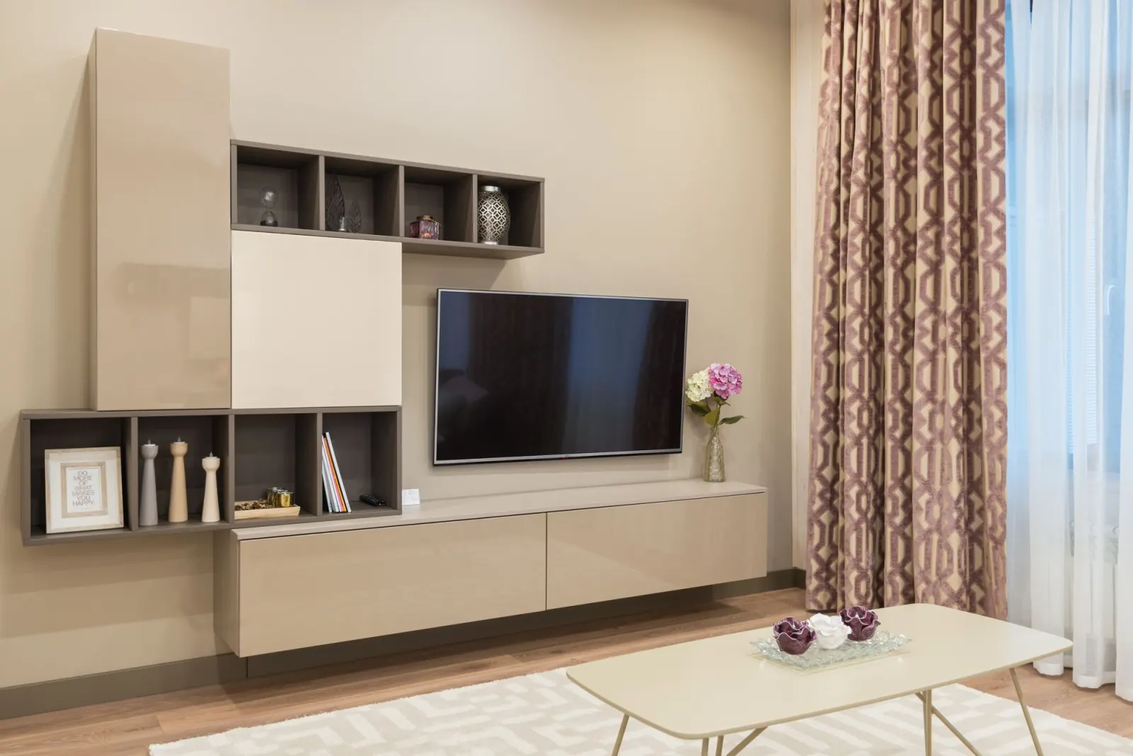 Raflı modüler TV ünitesi ve duvara asılı televizyonlu salon